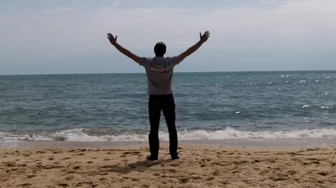 A man on the beach happy rase hands Stock Footage 50374483