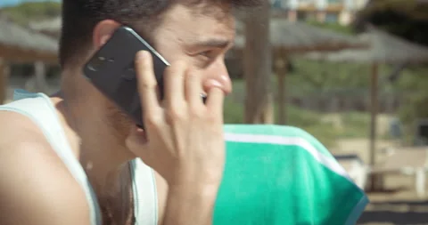 Man on the beach has a phone conversation Video stock 205022937