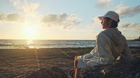 Man on a beach is looking distance during beautiful summer sunset. Human lo.. Stock Footage 254655059