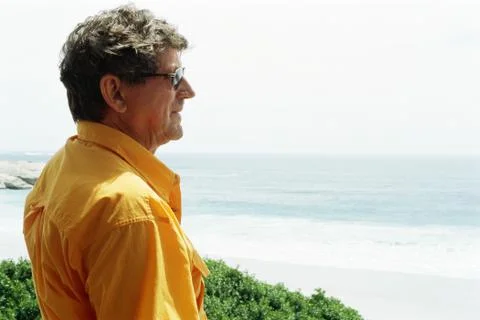 Man at the beach, looking at view, side view Stock Photos