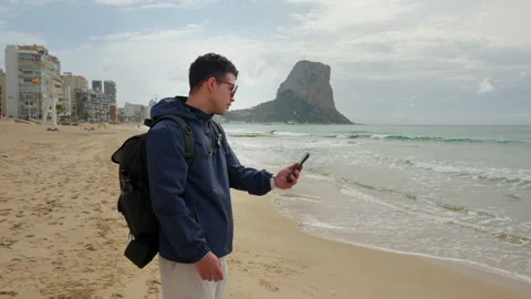Man on the beach making a stressed video call on his phone Stock-Footage 333690420