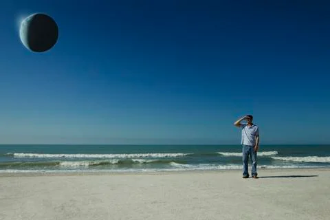 Man on beach observing eclipse Stock Photos