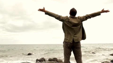 Man at the beach rising hands to the sky  Stock-Footage 1055754