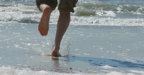 Man on beach running into the water - 4K UHD slow motion Stock Footage 48688095