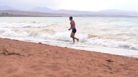 Man on the beach by the sea Stock Footage 95834483