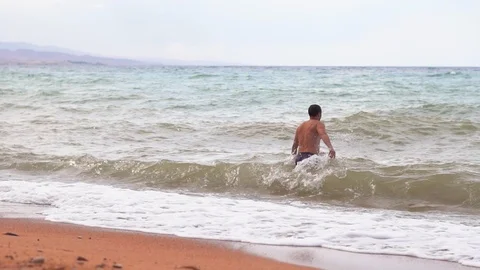 Man on the beach by the sea Stock Footage 95977384