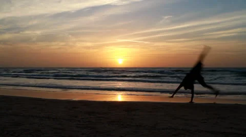 Man on the beach at sunset Stock Footage 22542630