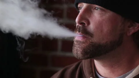 Man in Beanie Cap Vapes Smokes an E-Cigarette - Profile Stock Footage 46062423