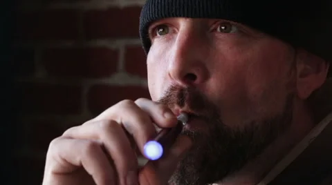 Man with Beanie Cap Vapes Smokes an E-Cigarette Stock Footage 46063682