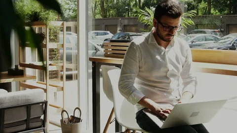 Man with bear and glasses freelancing in the cafe with street view Stock Footage 112985814
