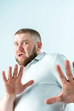 A man with a beard is afraid and puts his hands forward Stock Photos