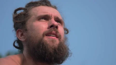 A man with a beard against the sky looks into the distance. Stock Footage 234020113