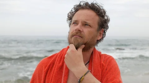 Man with a beard and blue eyes on the background of the sea after bathing. 4 k Stock Footage 108112912