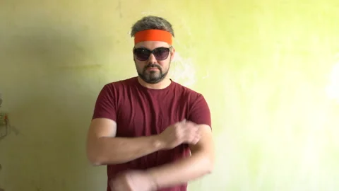 A man with a beard and dark glasses. Standing at the wall. Video stock 125638759