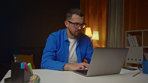 A man with a beard and eyeglasses is looking at the laptop with disappointment Stock Footage 172094322