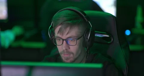 Man with a beard and glasses working at a computer, talking on a microphone. Man Video stock 127009575