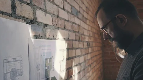 Man with a beard and glasses works in a loft-style office 스톡 동영상 73672544