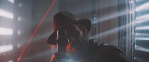 Man with beard and hat playing with vintage camera in laser lights Stock Footage 203561634