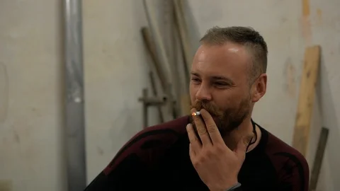 A man with a beard and mohawk smoking a cigarette Stock Footage 99578073