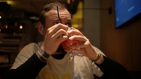 Man with a beard and mustache drinking a cocktail Stock Footage 99779251