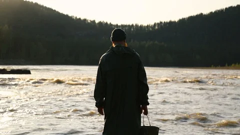 A man with a beard and mustache in a green raincoat falls to the ground. Stock Footage 111499883