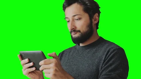 Man with a beard and mustache uses a tablet and smiles 스톡 동영상 75669619