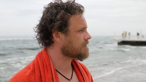 Man with a beard and a towel on his shoulders against the background of the sea Stock Footage 108112797