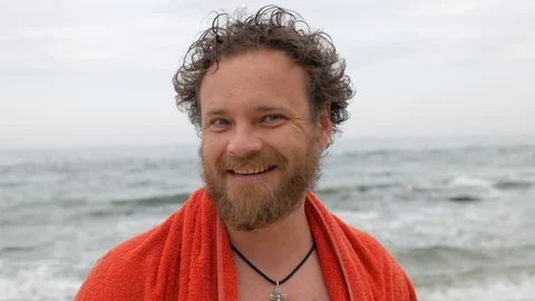 Man with a beard and a wet head against the background of the sea smiles. 4 k Stock Footage 108112785