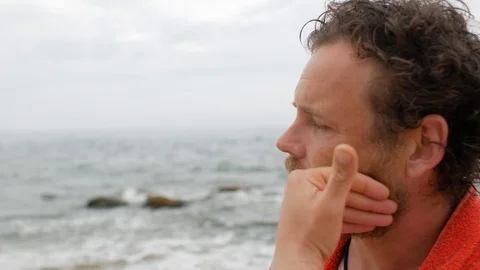 Man with a beard on the background of the sea after bathing  strokes his beard Stock Footage 108113010