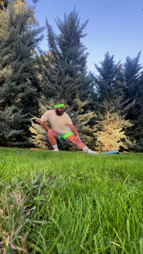 Man with beard, big belly, green shorts stands in surfer pose 스톡 동영상 326826035