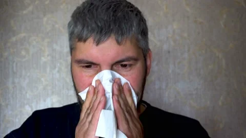 A man with a beard blows his nose in a scarf 4K Video stock 117174015