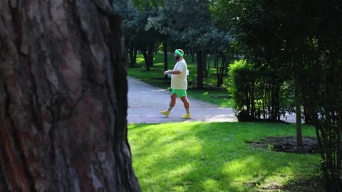 Man with beard, blue yoga mat walks on treadmill in city park Stock Footage 318729633