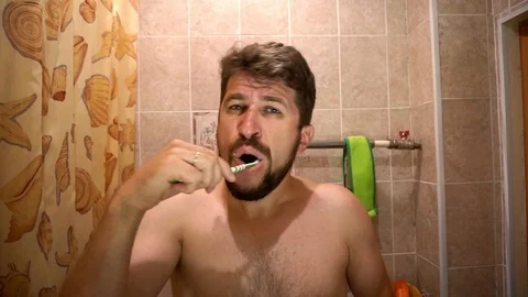 A man with a beard brushing his teeth Видео 93820192