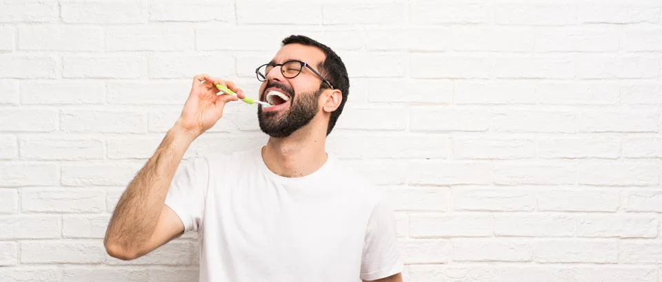 Man with beard brushing teeth Stock Photos
