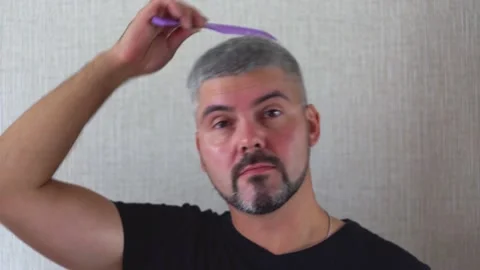 Man with a beard combing his head 4K Stock Footage 205569384