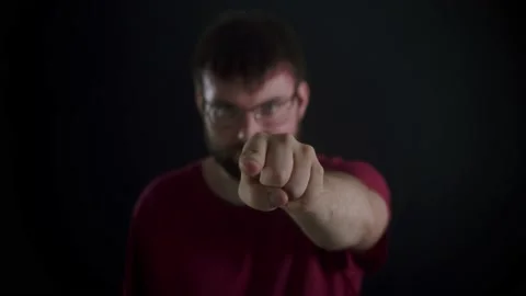 A man with a beard confidently adjusts his glasses and points his finger Stock Footage 169667538