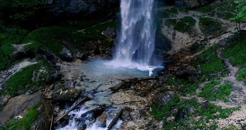 Man with beard is doing waterfall-meditation under big waterfall Stock Footage 90776992