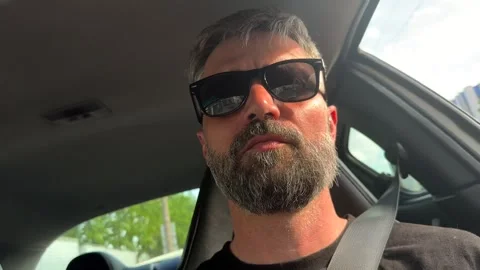 A man with a beard driving a car. Close-up. Stock Footage 334633736