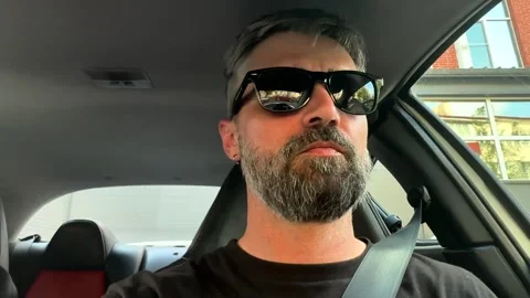 A man with a beard driving a car. Close-up. Stock Footage 334633898