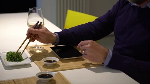 Man with a beard eating chuka salad and drinking white wine during the .. Stock Footage 71563116