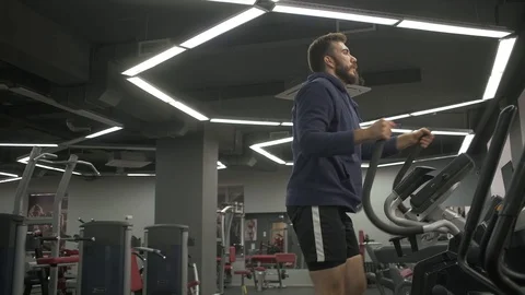 The man with the beard is engaged in the simulator stepper during a workout. Stock Footage 129572322