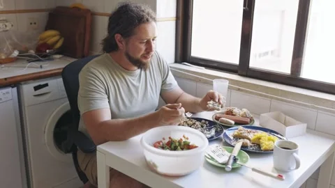 Man with a beard enjoying healthy breakfast in a kitchen Stock Footage 319645570