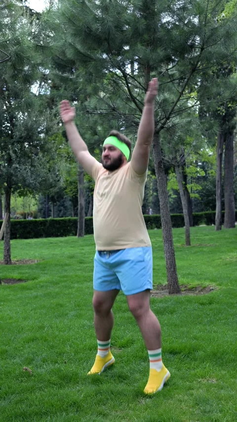 Man with beard, fat belly jumping and clapping in city park Stock Footage 306155553