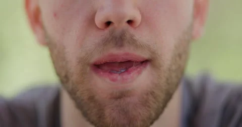 Man with a beard focuses intensely on camera during outdoor activity in bright Stock Footage 346659662