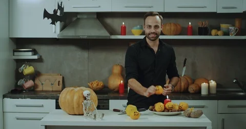 A man with a beard in front of the camera at his kitchen , Halloween atmosphere Stock Footage 96418389