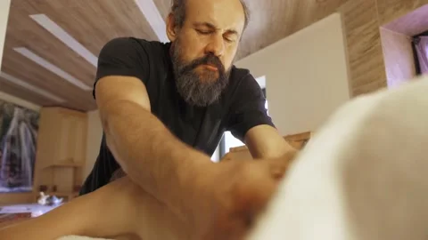 Man with a beard gives a back massage to a woman Stock Footage 140993692