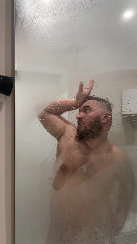 Man with beard grimaces in hotel bath room near mirror Stock Footage 307079219