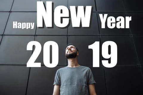 A man with a beard, the guy is looking up, against a black background. Text H Stock Photos