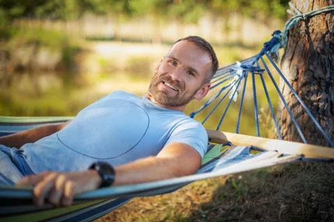 Man with a beard in a hammock in nature. Stock Photos