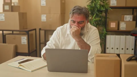 Man with beard hand on chin while colleague points at laptop in building; m.. Video stock 339201612